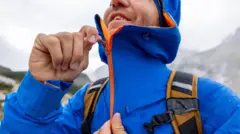 Hombre subiéndose el cierre de una chaqueta para la lluvia