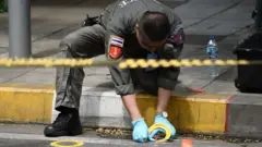 เจ้าหน้าที่เก็บหลักฐานหนึ่งในจุดที่เกิดเหตุระเบิดในกรุงเทพฯ เมื่อ 2 ส.ค. 2562