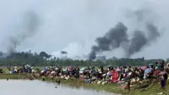 রাখাইনের গ্রামগুলো যে জ্বলছে তা বাংলাদেশ মিয়ানমারের সীমান্ত থেকে স্পষ্ট দেখা গেছে। দুই দেশের সীমান্তবর্তী নো-ম্যানস ল্যান্ডে অবস্থান করছে রোহিঙ্গা মুসলিমরা। ৪ঠা সেপ্টেম্বর, ২০১৭ সালে উখিয়া এলাকার ছবি।