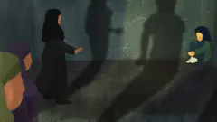 Three women approach a frightened girl, who is sitting in a ball in the corner of a dark room. Their shadows appear menacing.