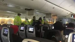 Abakozi bo mu ndege bafasha abagenzi mu gihe iyi ndege yari ihise ijya kugwa Hawaii kubera iki kibazo