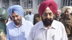 9 ਮਾਰਚ 2016 ਨੂੰ ਅੰਮ੍ਰਿਤਸਰ ਸਮੂਹਿਕ ਖ਼ੁਦਕੁਸ਼ੀ ਕੇਸ ਦੇ ਮੁੱਖ ਮੁਲਜ਼ਮ ਕੁਲਤਾਰ ਸਿੰਘ (ਲਾਲ ਪੱਗ) ਹਰਦੇਵ ਸਿੰਘ (ਅਸਮਾਨੀ ਪੱਗ) ਸੁਣਵਾਈ ਤੋਂ ਬਾਅਦ ਅੰਮ੍ਰਿਤਸਰ ਦੀ ਇੱਕ ਆਦਾਲਤ ਵਿੱਚੋਂ ਬਾਹਰ ਆਉਂਦੇ ਹੋਏ