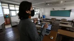 텅 빈 교실에 서 있는 교사