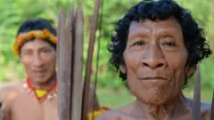 Karapiru, à direita, olha diretamente para a camera