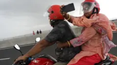 পদ্মা সেতুতে চলন্ত মোটর সাইকেল থেকে একজন আরোহী মোবাইল ফোন ক্যামেরায় ভিডিও করছেন, ২৬/০৬/২০২২