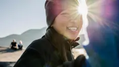 Moça numa montanha sorri