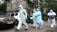 специалисты в защитных костюмах