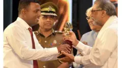 මැගසින් බන්ධනාගාරයේ ජ්‍යෙෂ්ඨ බන්ධනාගාර අධිකාරී ජගත් වීරසිංහ ඇතුළු බන්ධනාගාර නිලධාරීන්ගේ ආරක්‍ෂාව මධ්‍යයේ, ඔහු බුද්ධ ශාසන, ආගමික හා සංස්කෘතික කටයුතු රාජ්‍ය අමාත්‍ය විදුර වික්‍රමනායක අතින් සම්මානය ලබා ගනිමින්
