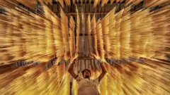 এক ব্যক্তি মাথার ওপর শুকাতে দেয়া সেমাই তত্ত্বাবধান করছেন