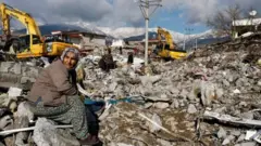 Туркиядаги вайроналар устида ўтирган кекса турк аёл