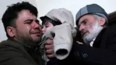 Hamid Safi, a 29-year-old taxi driver who had found baby Sohail Ahmadi in the airport, cries as he hands over Sohail to his grandfather Mohammad Qasem Razawi in Kabul
