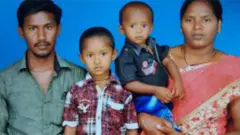 Sujith on his mother's arm with his brother and father
