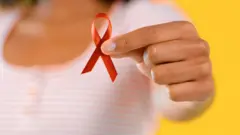 Mujer con un lazo en apoyo a los enfermos de VIH