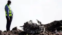 رجل يقف أمام حطام طائرة