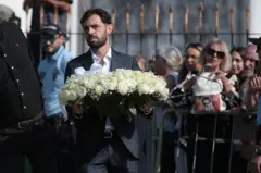 Bernardo Silva, do Manchester City, entra na igreja com uma coroa de rosas brancas