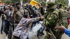በተቃውሞው ላይ አንዲት ሴት ፖሊሶችን ስትከላከል