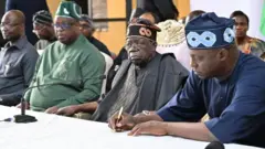 Bola Tinubu wear black attire and brown cap