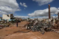 Terreno mostra casas destruídas e vários entulhos espalhados