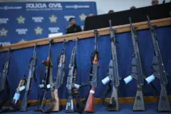 Fuzis apreendidos enfilerados durante conferência de imprensa após operação em comunidades do Rio de Janeiro