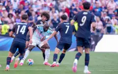 El jugador belga Romelu Lukaku entre varios jugadores de Estados Unidos.