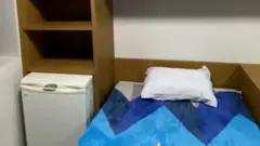 Cama e frigobar em sala da PF