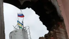 Российский флаг сквозь пробоину в стене