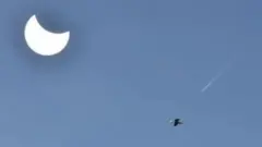 Uma vista de Weston-super-Mare, no Reino Unido, mostra o eclipse parcial contra um céu azul claro