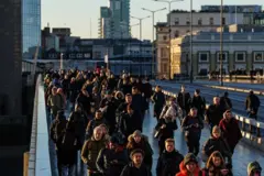 Uma multidão de pessoas atravessa a London Bridge