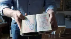 Mężczyzna trzymający otwarte paszporty