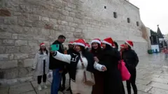 Abakerarugendo bari kwifotoreza iruhande rwa Kiliziya y'Ivuko, aho bemera ko ariho Yezu Kristu yavukiye