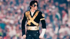 Umuririmbyi Michael Jackson, yambaye umukara n'ibara rya zahabu, ifoto yafashwe 1993 Pasadena muri California, Super Bowl XXVII hagati mu gitaramo.