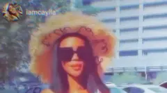 Mulher jovem com chapéu, óculos escuros e cabelo liso preto sorri para a câmera