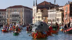 Čamac prevozi „Panteganu“, velikog pacova, preko Velikog kanala tokom Venecijanskog karnevala