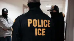 Agentes de ICE en un pasillo, con las caras cubiertas