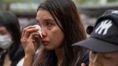  Hong Kong'ta yapılan anma töreninde bir kadın gözyaşlarını mendille siliyor. Ağlamaktan gözleri kızarmış bir durumda