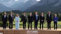 European Council President Antonio Costa, Japanese Prime Minister Shigeru Ishiba, Italian Prime Minister Giorgia Meloni, French President Emmanuel Macron, Canadian Prime Minister Mark Carney, US President Donald Trump, British Prime Minister Keir Starmer, German Chancellor Friedrich Merz, and European Commission President Ursula von der Leyen pose for a family photo during the Group of Seven (G7) Summit at the Kananaskis Country Golf Course in Kananaskis, Alberta, Canada