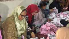 চট্টগ্রামের একটি কেন্দ্রে ভোট গণনা করতে দেখা যাচ্ছে