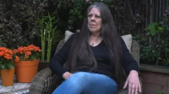 Loreen Willenberg, uma mulher de meia idade e cabelos longos, veste jeans e camisa de manga comprida preta