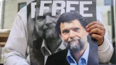 Osman Kavala'ya Özgürlük yazılı Kavala'nın posterini tutan bir el