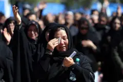 Uma mulher iraniana chora durante o funeral das vítimas.