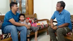 সন্তানকে কোলে জড়িয়ে আছেন বাসিত খান মুসার বাবা মুস্তাফিজুর রহমান