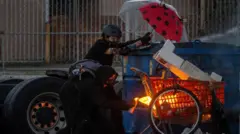 Un manifestante prende fuego a un carrito de compras durante un enfrentamiento con la policía.