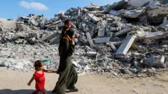Palestinians make their way to return to neighbourhoods in the eastern side of Khan Younis after Israeli forces pulled out from the area, amid the Israel-Hamas conflict, in Khan Younis, in the southern Gaza Strip on 30 July 2024