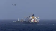 Helicóptero sobrevoa navio