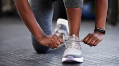 Cropped foto of unrecognizable woman as she dey tie her shoelaces for gym