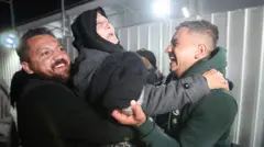 امرأة فلسطينية يستقبلها أبناؤها عند معبر رفح.