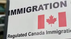 A flag of Canada wit inscription of 'immigration'