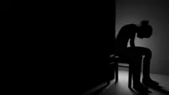 ኣብ ፀልማት ኮፍ ዝበለት መንእሰይ