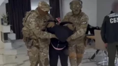 Двое сотрудников СБУ ведут задержанного