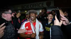 Ian Wright celebrates with Arsenal fans after the Gunners secure Premier League title